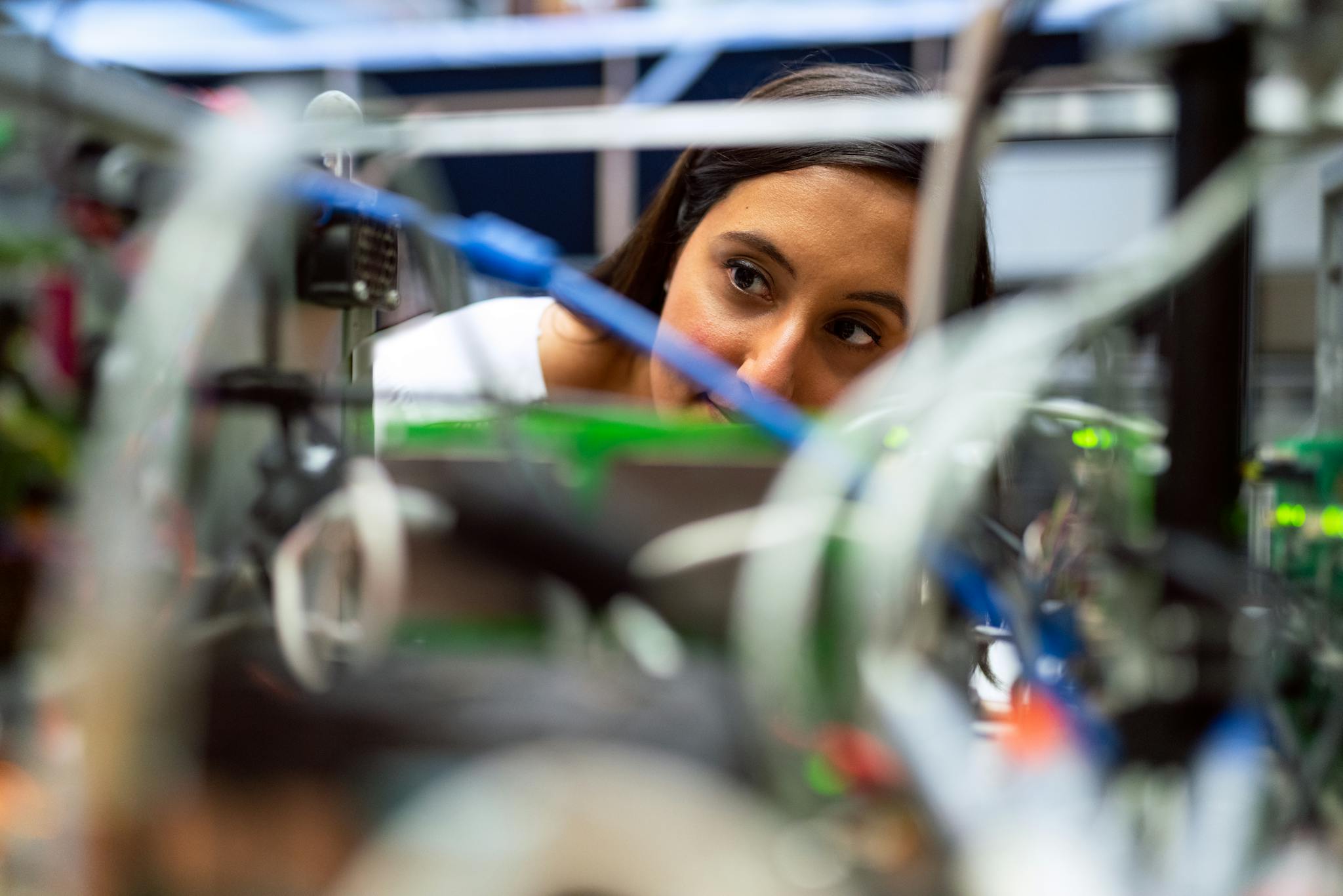 Focused female engineer analyzing equipment at a modern lab.